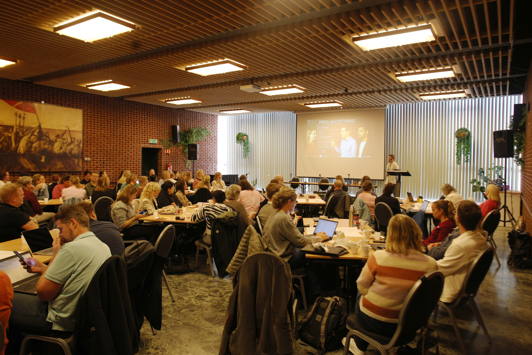 foran en fullsatt sal.