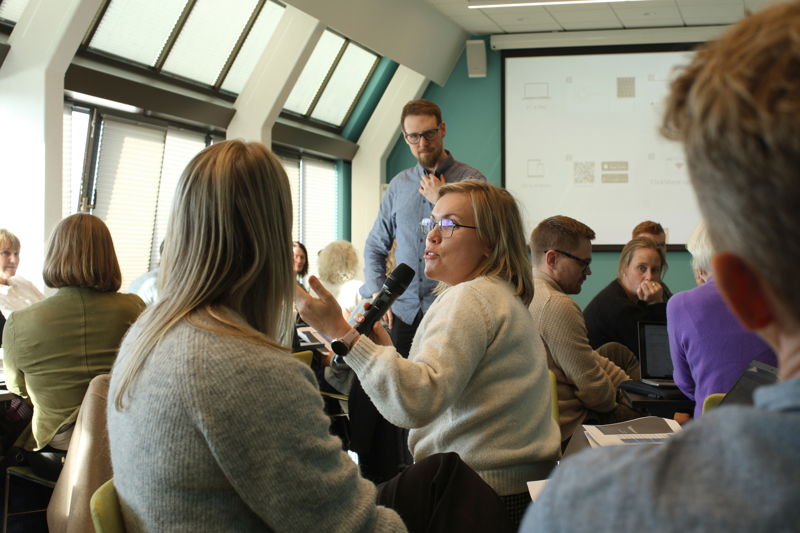 Folk i ivrig diskusjon i salen