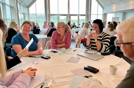 Bildet viser personer som sitter i samtale rundt bordet på e-helse samlingen.