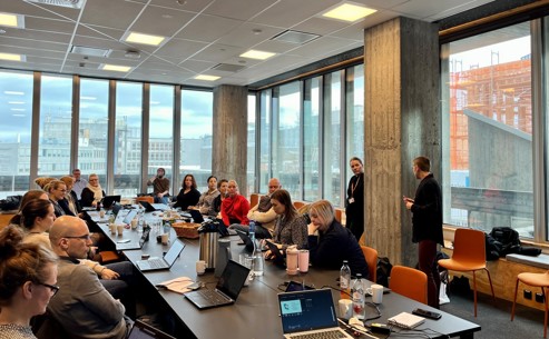 Bildet viser konferanserommet hvor deltakerne sitter rundt bordet og jobber med ChatPGT: