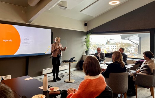 Bildet viser Ellen Bowitz som holder en presentasjon, og vi ser flere deltakere som lytter til henne.