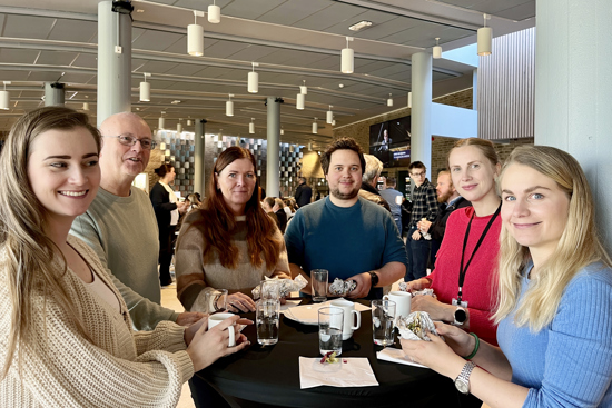 Bildet viser en gjeng ansatte fra Gjesdal kommune som står rundt et bord. De ser på fotografen.