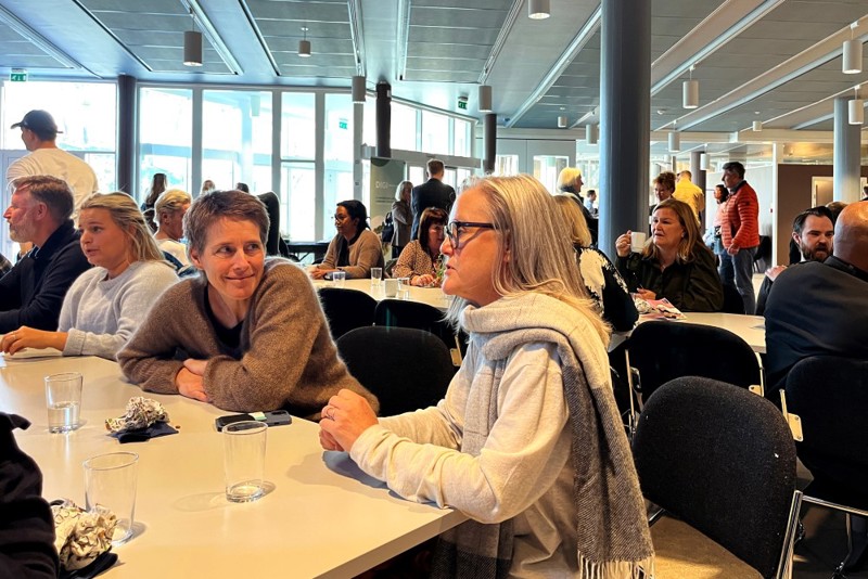 Bildet viser Christine Sandvold som sitter på et bord sammen men andre konferansedeltakere. 